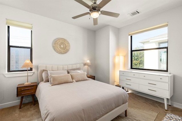 carpeted bedroom featuring ceiling fan, visible vents, and baseboards