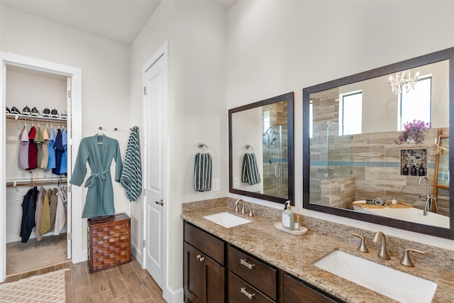 full bathroom with a stall shower, a spacious closet, and a sink