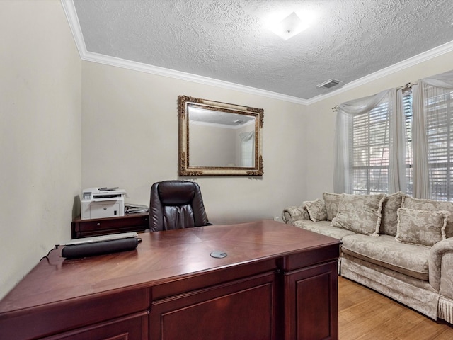 office area with visible vents, crown molding, light wood-style flooring, and a textured ceiling