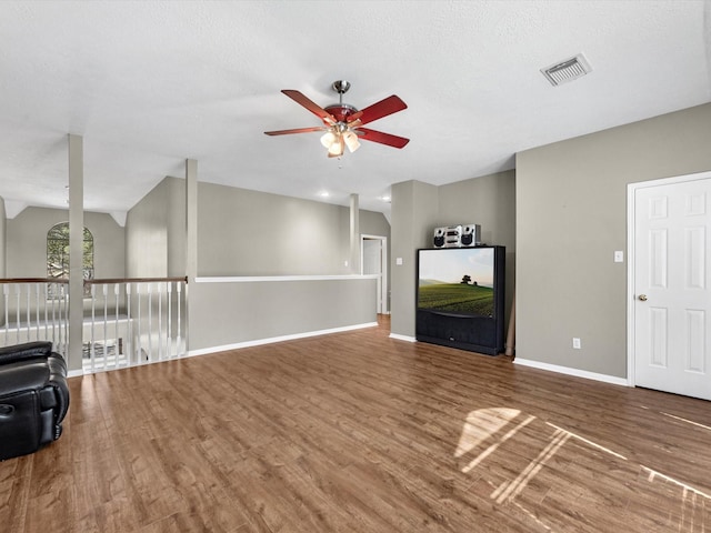 unfurnished living room with a ceiling fan, baseboards, visible vents, and wood finished floors