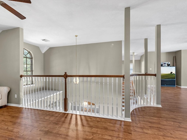 hallway with visible vents, baseboards, and wood finished floors