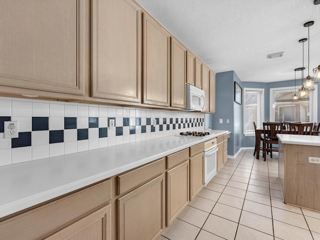 kitchen featuring light tile patterned floors, white appliances, visible vents, light countertops, and tasteful backsplash