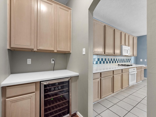 bar with white appliances, light tile patterned floors, decorative backsplash, wine cooler, and a textured ceiling