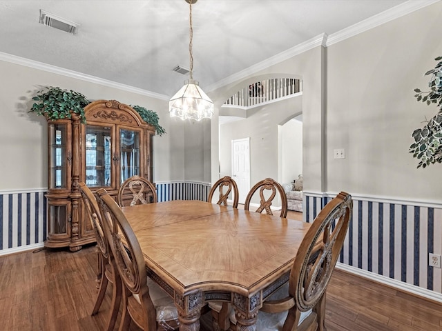 dining space featuring wallpapered walls, visible vents, arched walkways, and wood finished floors