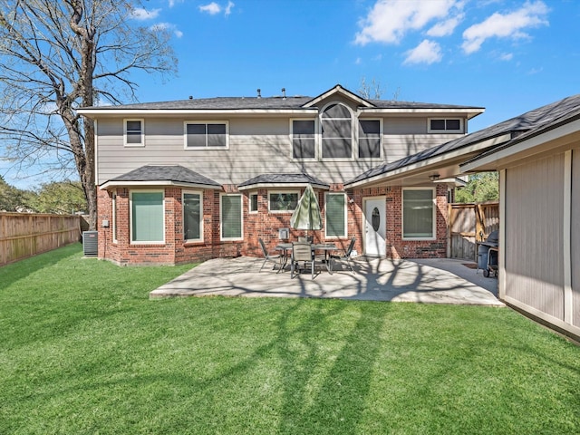 back of house with cooling unit, brick siding, fence, a yard, and a patio area