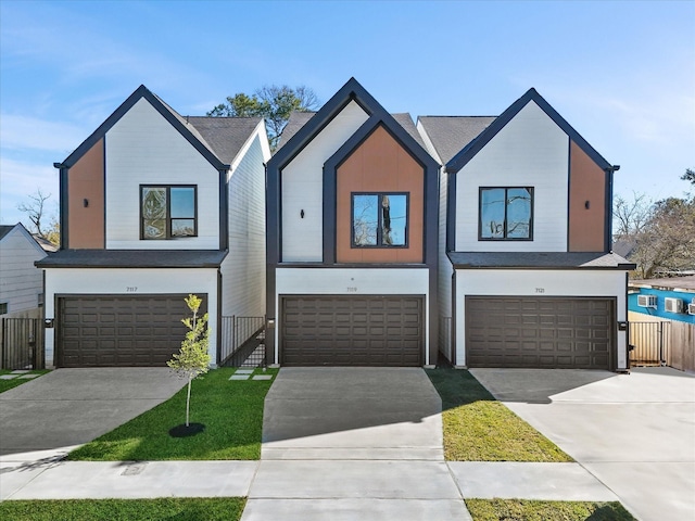 view of front of house featuring concrete driveway, fence, and an attached garage