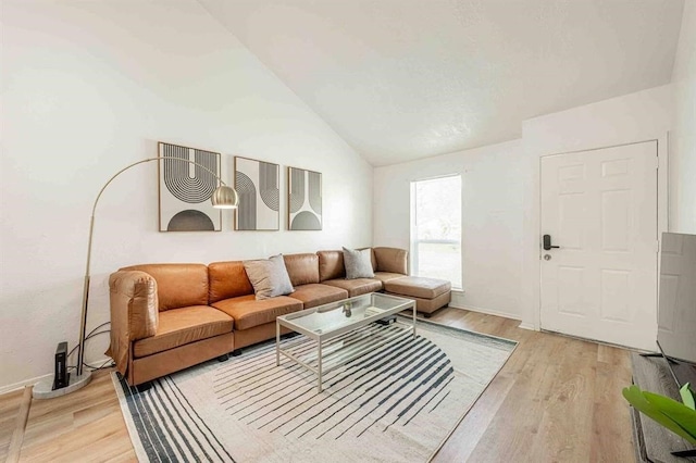 living area featuring lofted ceiling and light wood-style floors