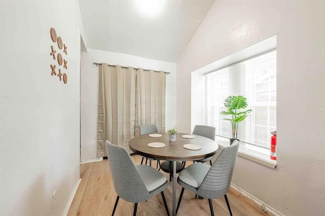 dining space featuring baseboards and light wood finished floors