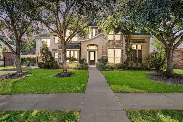 view of front of house with stone siding, brick siding, and a front lawn