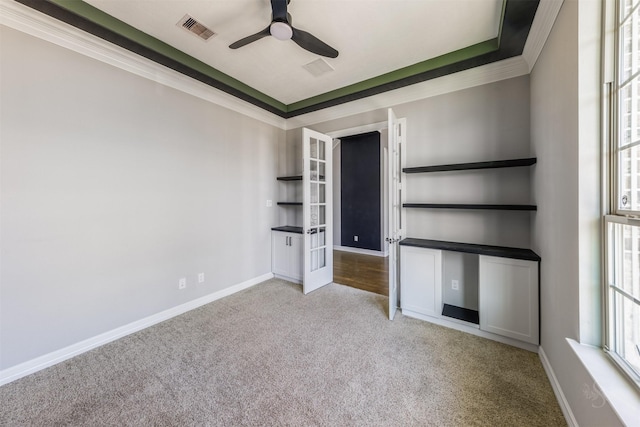 unfurnished bedroom featuring baseboards, carpet flooring, visible vents, and crown molding