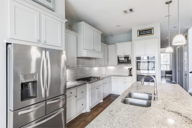 kitchen with tasteful backsplash, visible vents, white cabinets, stainless steel appliances, and a sink