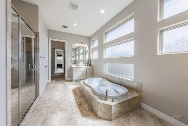 bathroom with visible vents, a stall shower, vanity, baseboards, and a bath