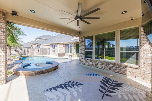 view of patio with a pool with connected hot tub, fence, and a ceiling fan