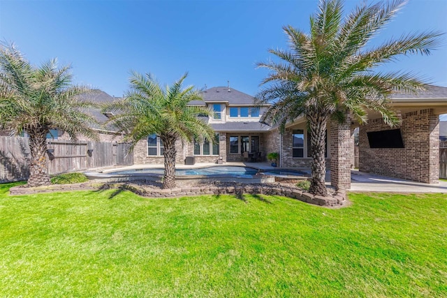 back of property featuring brick siding, fence, a yard, a fenced in pool, and a patio area