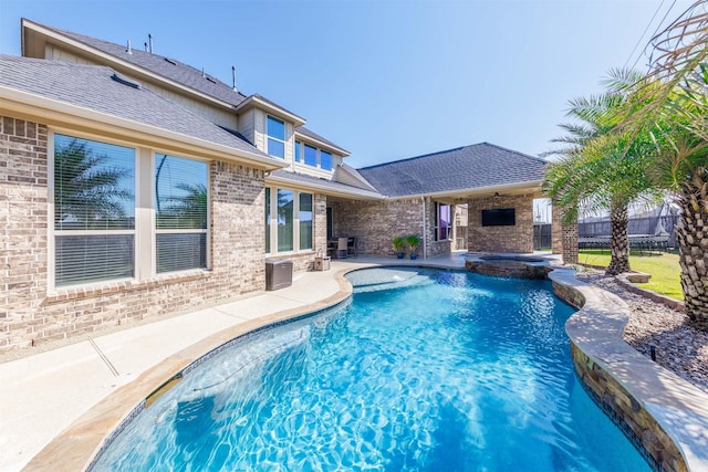 view of pool with a patio, ceiling fan, a trampoline, fence, and a pool with connected hot tub