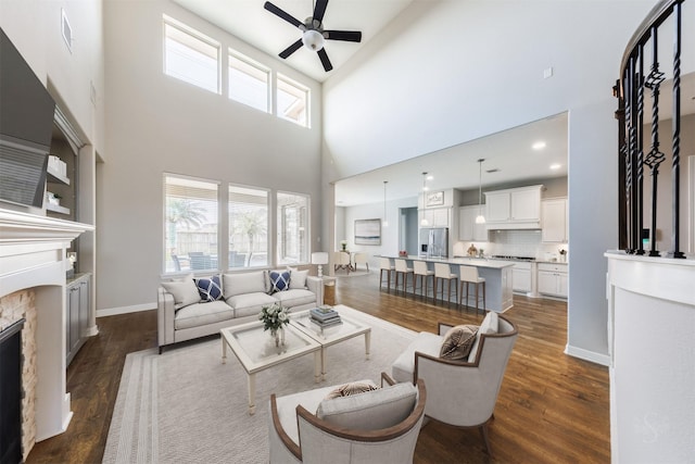 living area with a healthy amount of sunlight, a fireplace, and dark wood finished floors