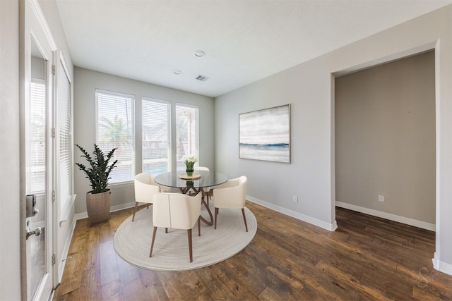 dining room featuring dark wood-style floors, visible vents, and baseboards