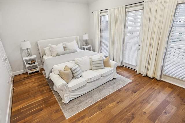 bedroom with access to outside, baseboards, and wood finished floors