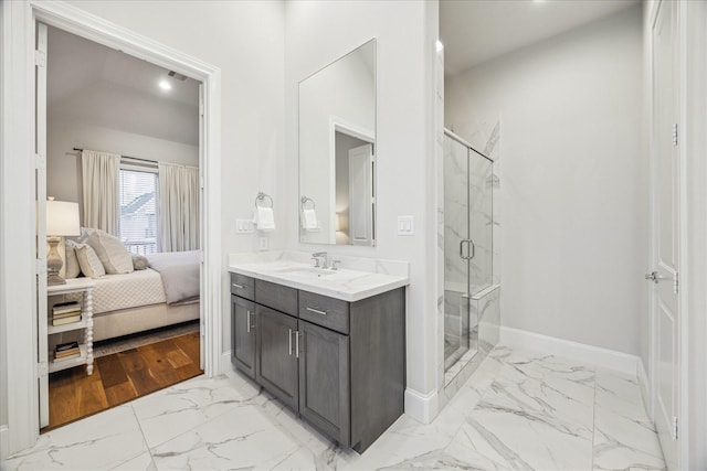 bathroom with ensuite bathroom, vanity, baseboards, marble finish floor, and a shower stall