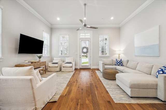 living area featuring hardwood / wood-style flooring, baseboards, crown molding, and recessed lighting