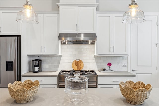 kitchen with tasteful backsplash, hanging light fixtures, appliances with stainless steel finishes, and under cabinet range hood