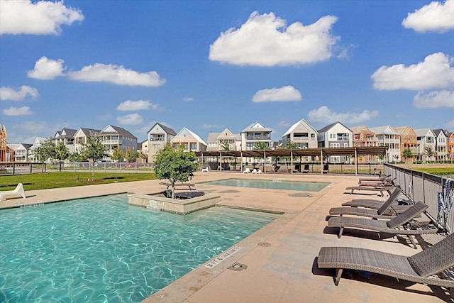 community pool featuring a residential view, fence, and a patio