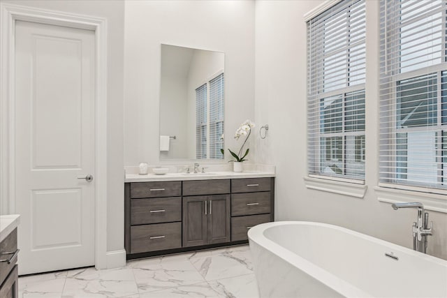 full bathroom with marble finish floor, a soaking tub, and vanity