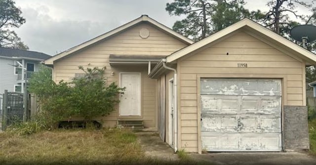 view of front of house featuring entry steps, a garage, and fence