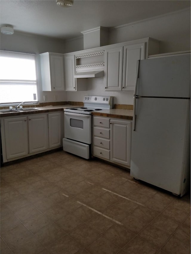 kitchen featuring dark countertops, white cabinets, and white appliances