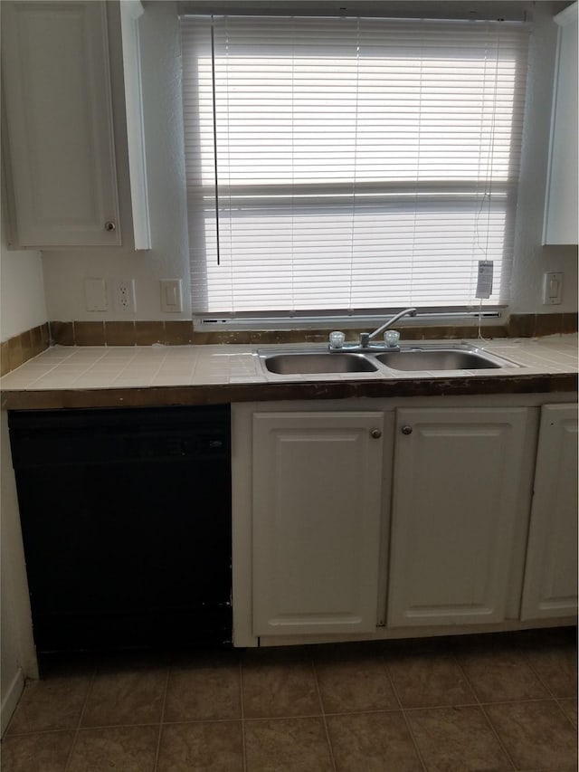 kitchen featuring a wealth of natural light, dishwasher, white cabinetry, and a sink