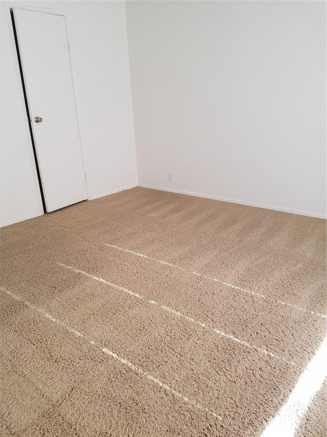 unfurnished bedroom featuring baseboards and carpet