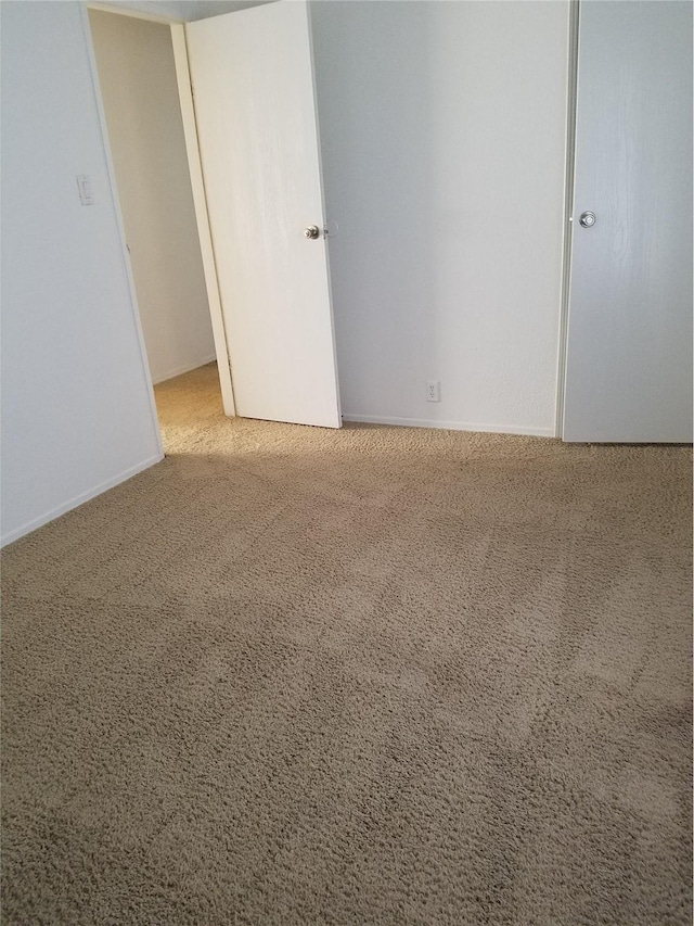 unfurnished bedroom with baseboards and carpet floors