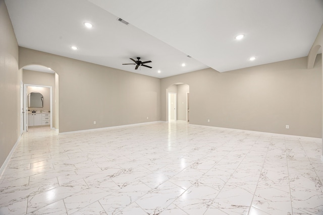 unfurnished room with ceiling fan, visible vents, arched walkways, and recessed lighting