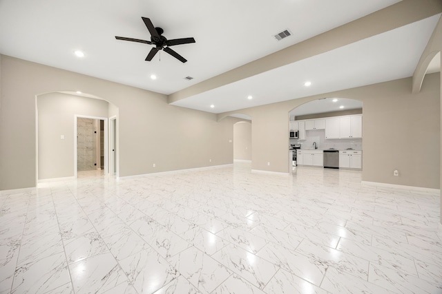 unfurnished living room with arched walkways, recessed lighting, visible vents, a ceiling fan, and marble finish floor