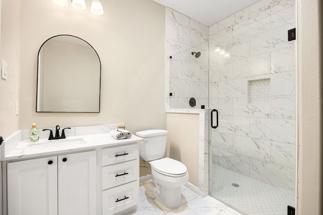 bathroom featuring marble finish floor, a stall shower, vanity, and toilet