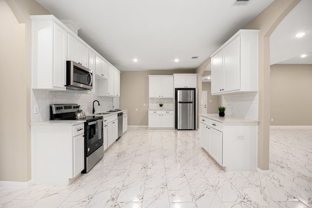 kitchen with marble finish floor, stainless steel appliances, and a sink