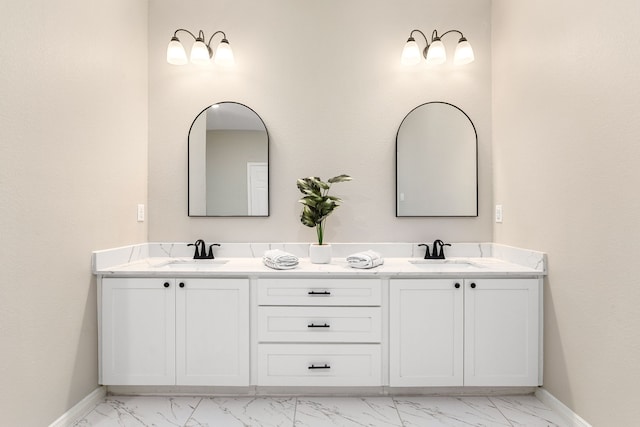 bathroom with marble finish floor, a sink, and baseboards