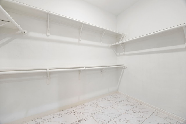 spacious closet featuring marble finish floor