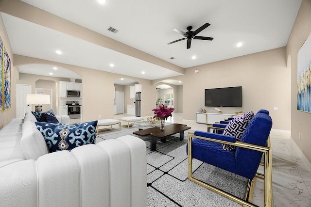 living area with arched walkways, marble finish floor, visible vents, and recessed lighting