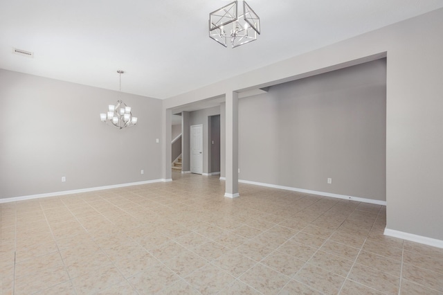 unfurnished room with a chandelier, stairway, and baseboards