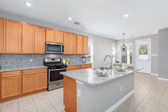 kitchen with light tile patterned floors, visible vents, stainless steel appliances, and a sink