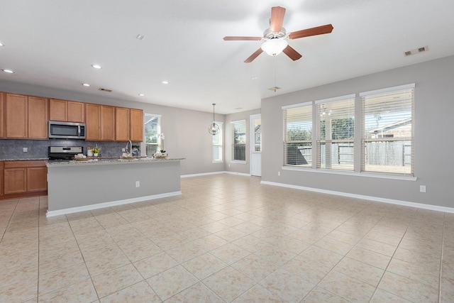 kitchen featuring light tile patterned flooring, visible vents, baseboards, appliances with stainless steel finishes, and backsplash