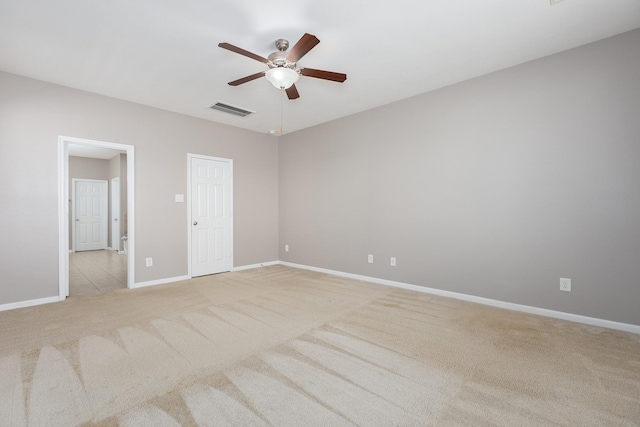 unfurnished bedroom with baseboards, visible vents, ceiling fan, and light colored carpet