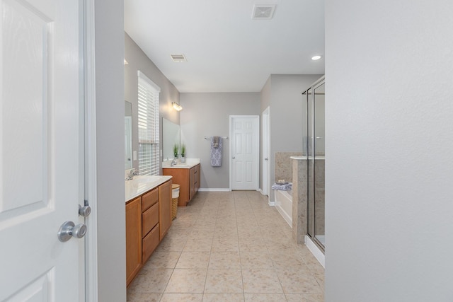 full bath with a stall shower, two vanities, visible vents, and tile patterned floors