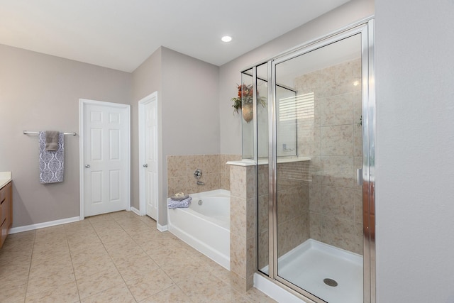 bathroom with tile patterned flooring, vanity, baseboards, a shower stall, and a bath