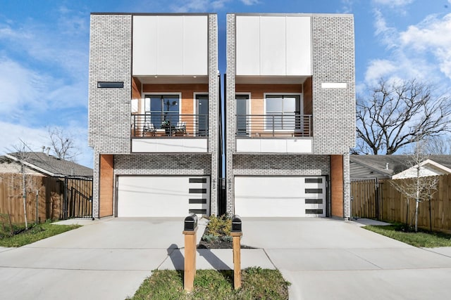 view of front of house with a garage, driveway, a gate, and a balcony