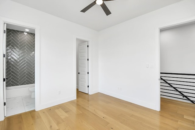 unfurnished bedroom featuring light wood-type flooring, baseboards, and ensuite bathroom