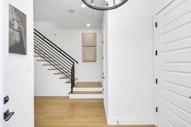 stairs with recessed lighting, visible vents, baseboards, and wood finished floors