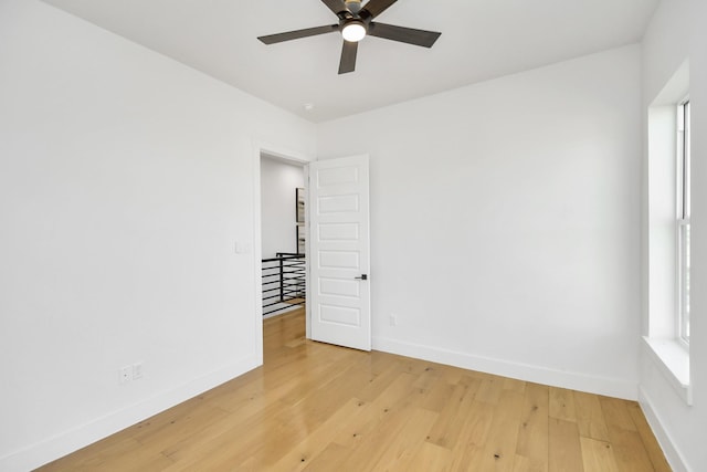 empty room featuring light wood-type flooring, ceiling fan, and baseboards