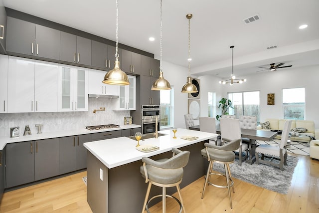 kitchen featuring stainless steel appliances, light countertops, open floor plan, and visible vents